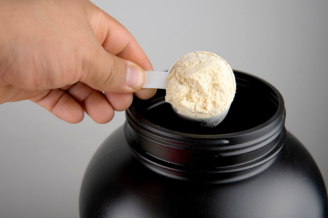 High-quality powder supplement manufacturing at Biowell Labs—scooping nutraceutical protein powder from a black container, highlighting contract supplement manufacturing and private label supplement production.