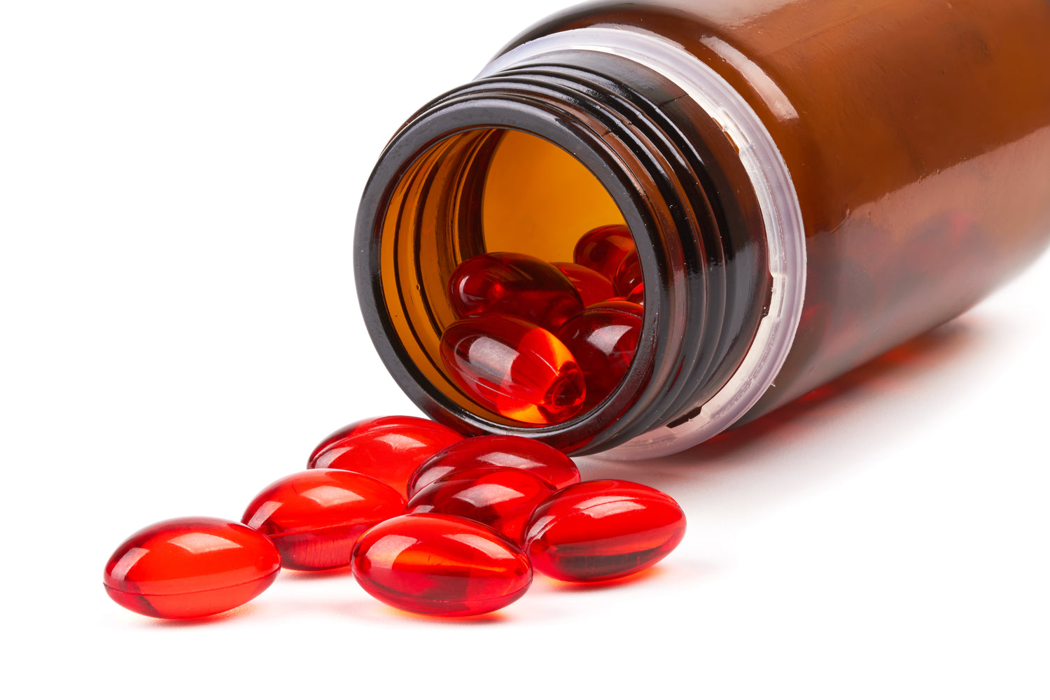 Premium softgel production at Biowell Labs—high-quality red softgel capsules spilling from an amber bottle, representing contract supplement manufacturing and private label nutraceuticals in a Health Canada approved facility.